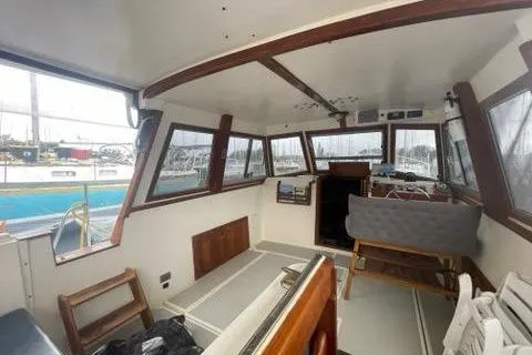 Slide: The Image of 1988 Albin 34 Cruiser interior with panoramic windows and seating in a marina setting. - 23
