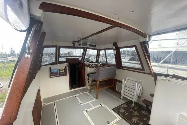 Slide: The Image of 1988 Albin 34 Cruiser interior with helm, seating, and panoramic windows. - 24
