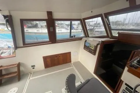 Slide: The Image of 1988 Albin 34 Cruiser interior with helm, windows, and marina view. - 27