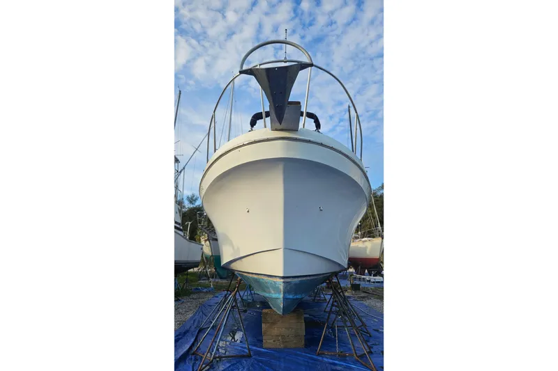 Slide: The Image of 1988 Albin 34 Cruiser boat on stands, viewed from the front under a blue sky. - 3