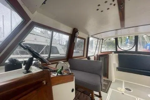 Slide: The Image of 1988 Albin 34 Cruiser interior with helm, seating, and large windows. - 32