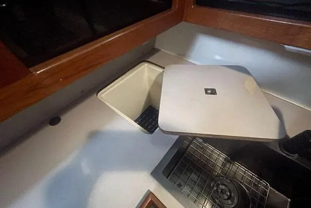 Slide: The Image of 1988 Albin 34 Cruiser kitchen area with sink and storage compartment. - 36