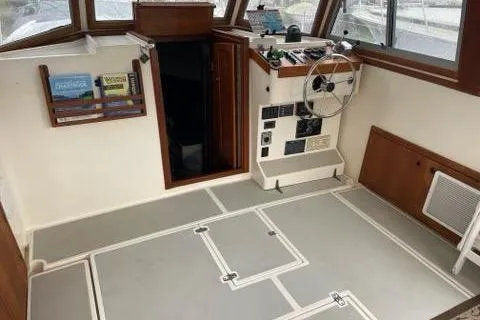 Slide: The Image of 1988 Albin 34 Cruiser interior with helm, wooden accents, and spacious layout. - 37