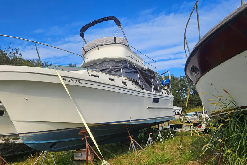Slide: The Image of 1988 Albin 34 Cruiser on stands, surrounded by grass, under a clear blue sky. - 39