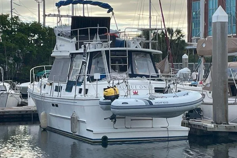 Slide: The Image of 1988 Albin 34 Cruiser docked with inflatable boat attached at marina. - 4