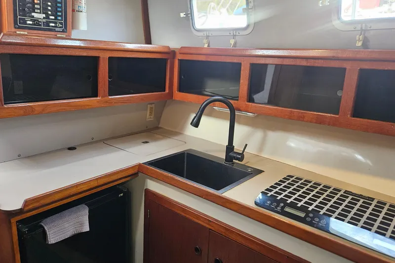 Slide: The Image of Interior of 1988 Albin 34 Cruiser kitchen with wooden cabinets and modern sink. - 42