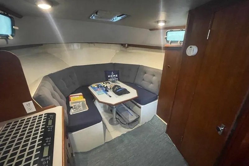 Slide: The Image of 1988 Albin 34 Cruiser interior with cozy seating and table, featuring nautical decor. - 5