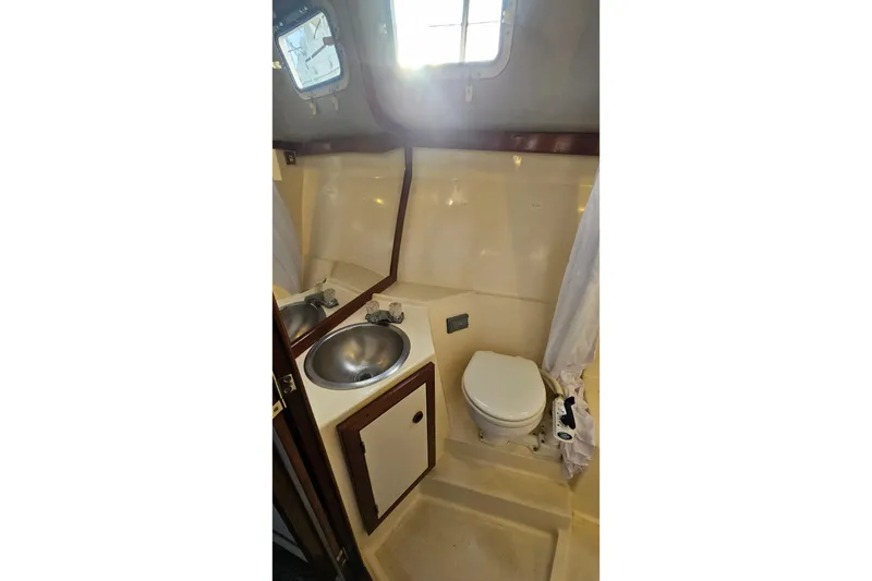 Slide: The Image of 1988 Albin 34 Cruiser bathroom with sink, toilet, and window. - 55