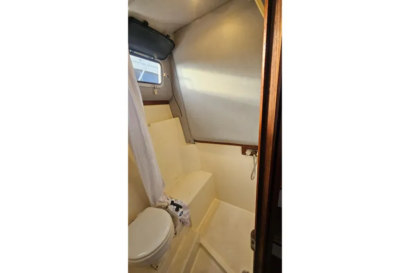 Slide: The Image of 1988 Albin 34 Cruiser bathroom interior with toilet and shower area. - 56