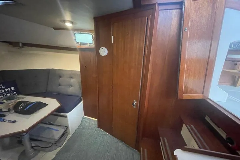 Slide: The Image of Interior of 1988 Albin 34 Cruiser with wooden cabinetry and cozy seating area. - 6