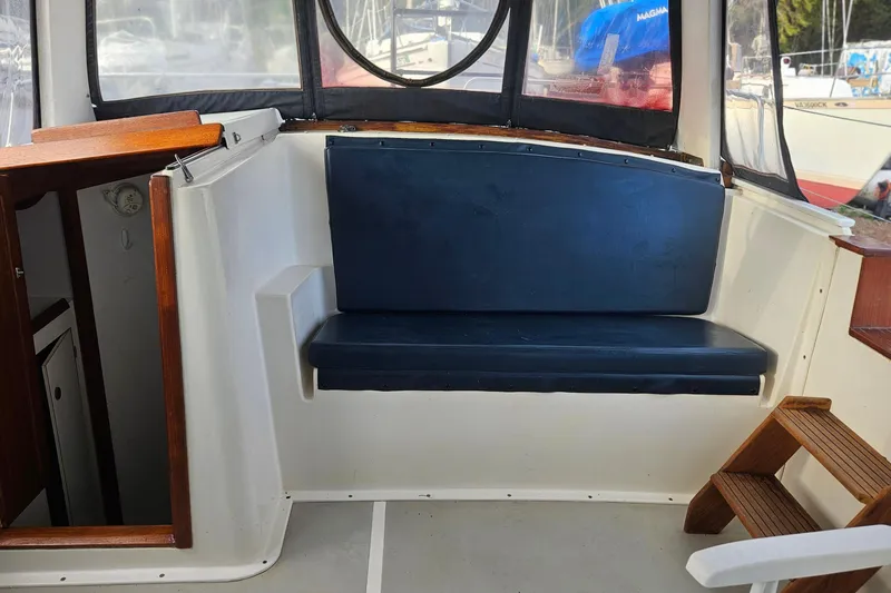 Slide: The Image of 1988 Albin 34 Cruiser interior with blue cushioned seating and wooden accents. - 67