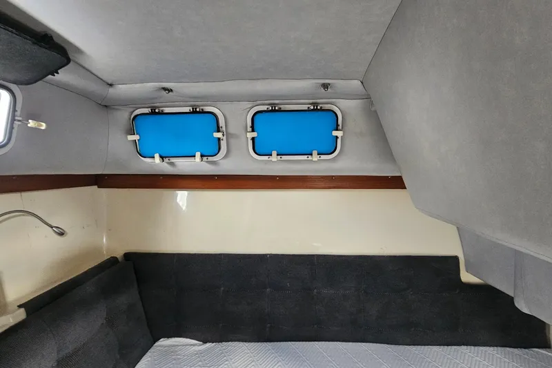 Slide: The Image of Interior cabin of 1988 Albin 34 Cruiser with blue portholes and gray upholstery. - 69