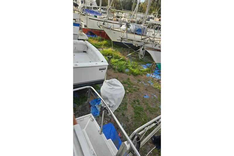 Slide: The Image of 1988 Albin 34 Cruiser in a boatyard, surrounded by other vessels. - 76
