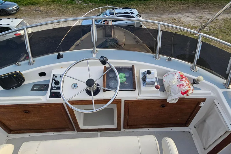 Slide: The Image of 1988 Albin 34 Cruiser helm with steering wheel, controls, and navigation equipment. - 77
