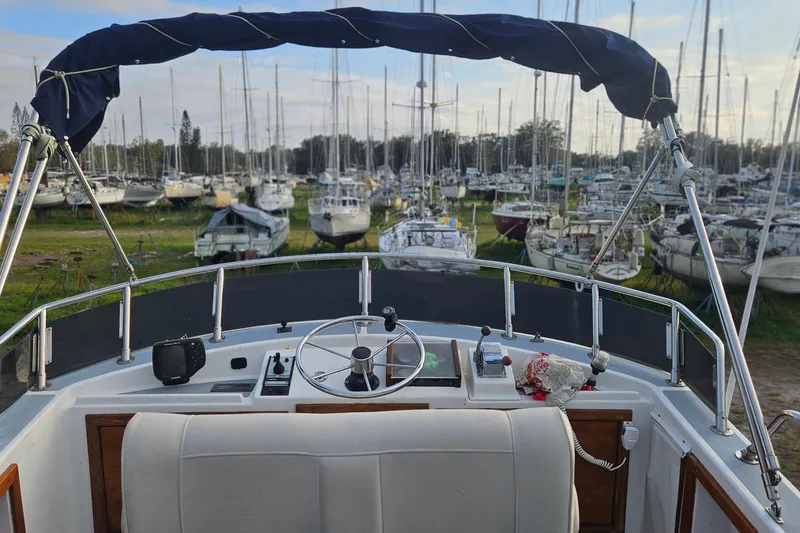 Slide: The Image of 1988 Albin 34 Cruiser helm view with boats in a marina background. - 79