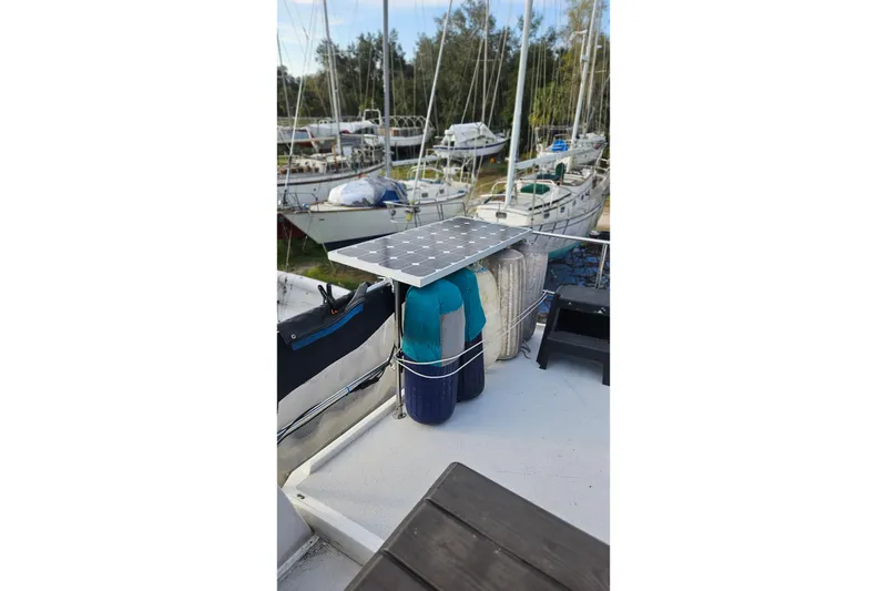 Slide: The Image of 1988 Albin 34 Cruiser with solar panel and docked sailboats in background. - 81