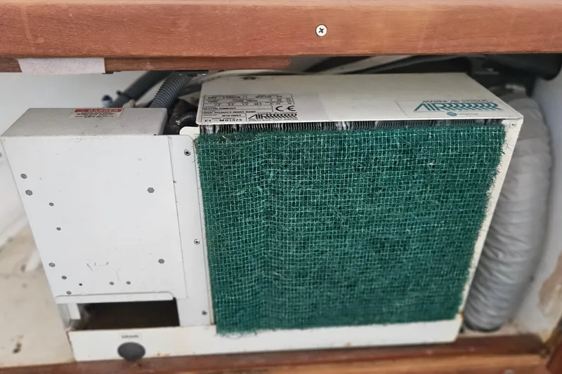 Slide: The Image of Air conditioning unit inside 1988 Albin 34 Cruiser boat, featuring green mesh filter. - 85