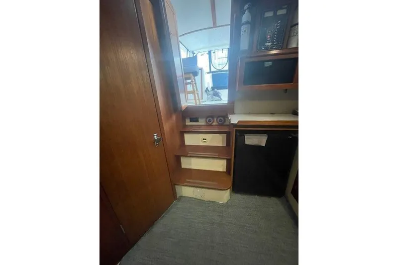 Slide: The Image of Interior of 1988 Albin 34 Cruiser with wooden cabinetry and compact kitchen area. - 9