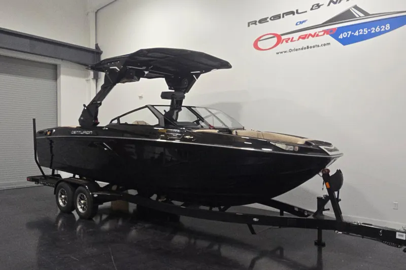 The Image of 2026 Centurion R1245 boat on trailer in showroom, sleek black design. - 1