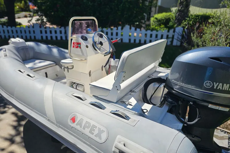 Slide: The Image of Inflatable Apex A-12 boat, 2005 model, with Yamaha outboard motor, parked outdoors. - 3