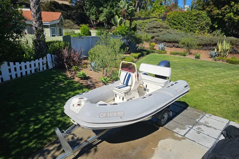 Slide: The Image of Inflatable boat Apex A-12 (2005) on trailer in a garden setting. - 4