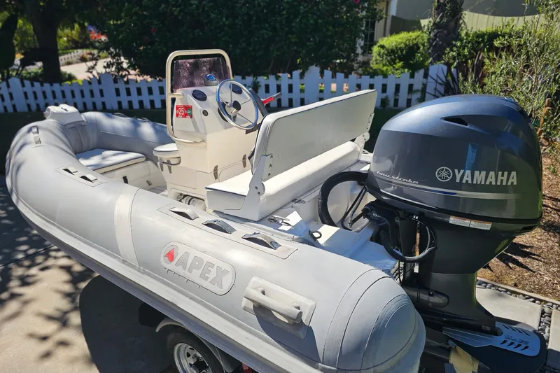 Slide: The Image of Inflatable Apex A-12 boat with Yamaha outboard motor, 2005 model, parked outdoors. - 5