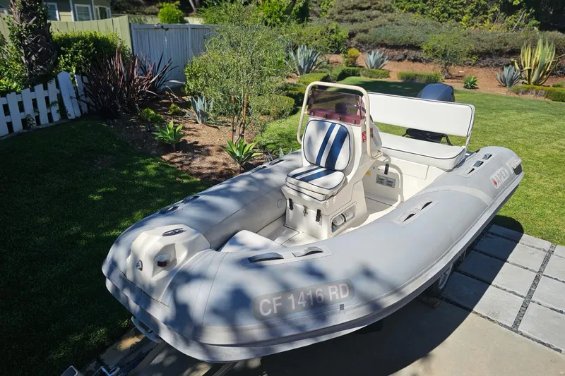 Slide: The Image of 2005 Apex A-12 inflatable boat in a garden setting, showcasing sleek design and seating. - 6