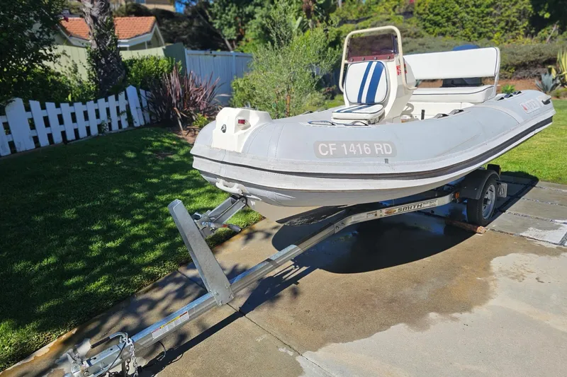 Slide: The Image of 2005 Apex A-12 inflatable boat on trailer in sunny backyard setting. - 7