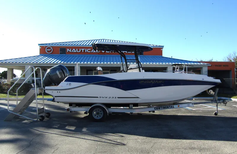 Slide: The Image of 2024 Starcraft SVX 231 OB CC boat on a trailer in a parking lot. - 1