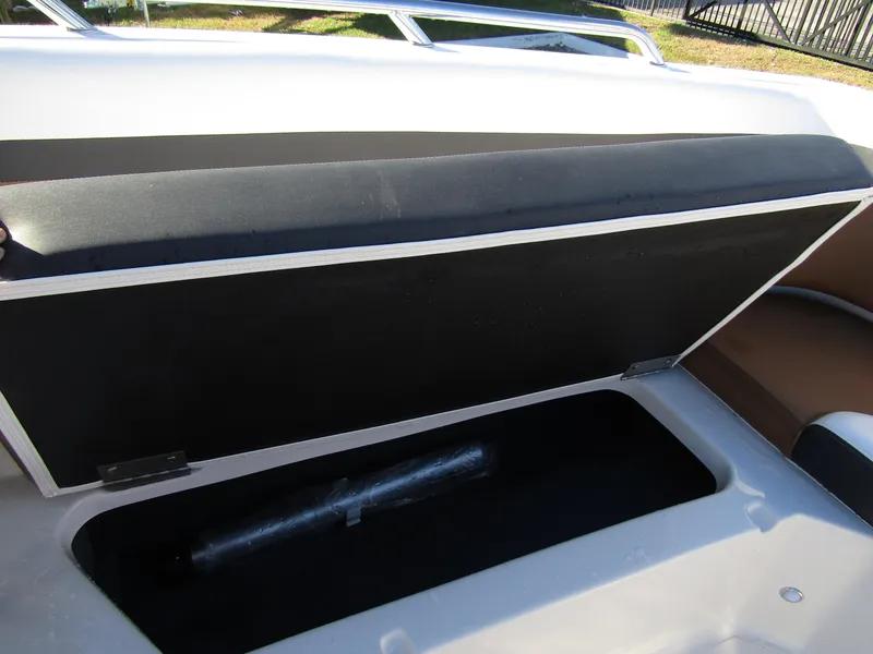 Slide: The Image of 2024 Starcraft SVX 231 OB CC boat seating area with storage compartment and cup holders. - 12