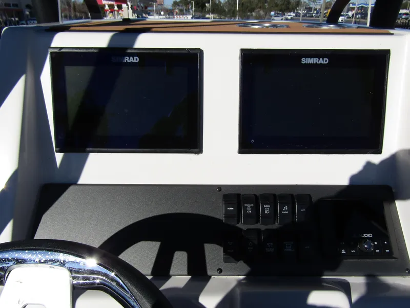 Slide: The Image of 2024 Starcraft SVX 231 OB CC boat console with steering wheel and controls. - 23