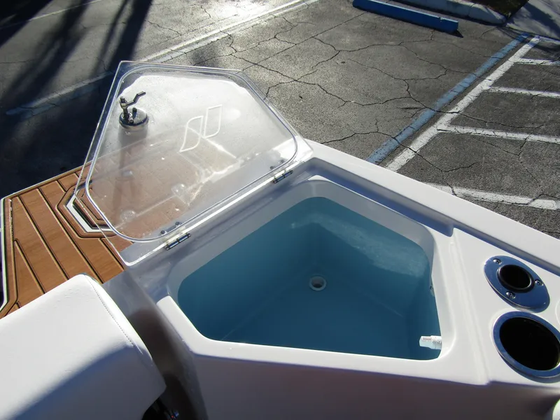 Slide: The Image of 2024 Starcraft SVX 231 OB CC boat deck with wood finish and storage compartment. - 29