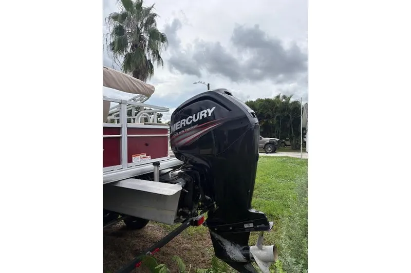 Slide: The Image of 2019 Sun Tracker Fishin' Barge 20 DLX with Mercury outboard motor, parked on grass. - 10