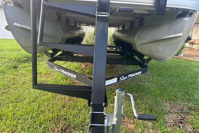 Slide: The Image of 2019 Sun Tracker Fishin' Barge 20 DLX on trailer, grassy background. - 4