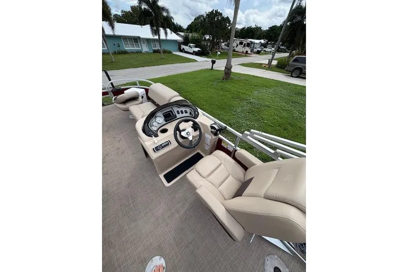 Slide: The Image of 2019 Sun Tracker Fishin' Barge 20 DLX interior with beige seating and control panel. - 5