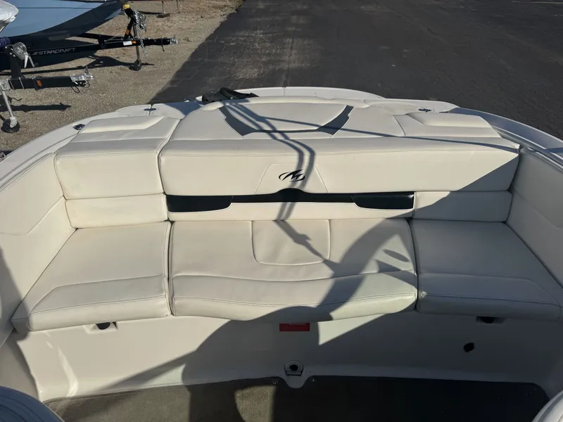 Slide: The Image of 2009 Monterey 194FS boat with white cushioned seating, parked on a paved surface. - 13