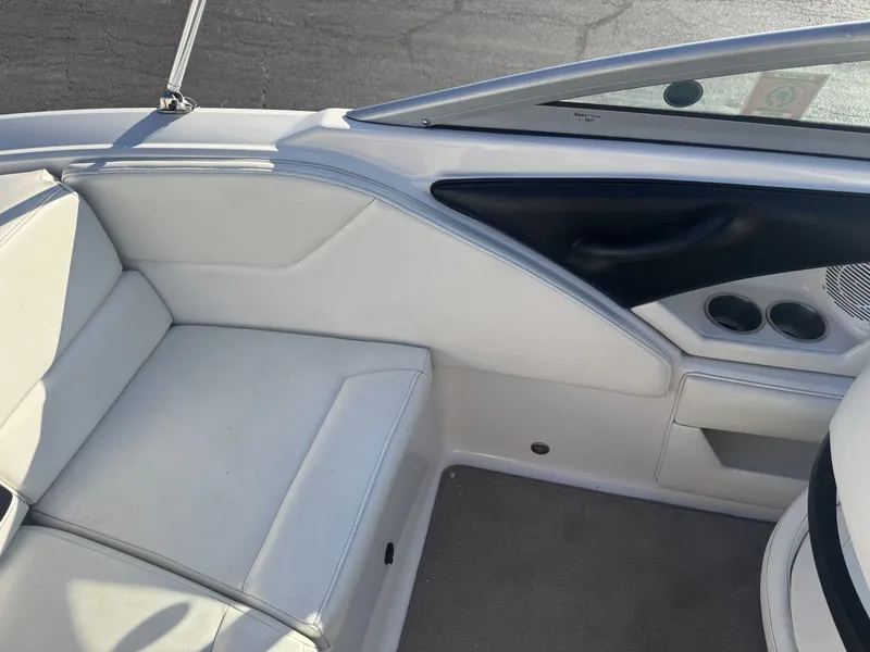 Slide: The Image of Interior of a 2009 Monterey 194FS boat, featuring white seating and cup holders. - 15
