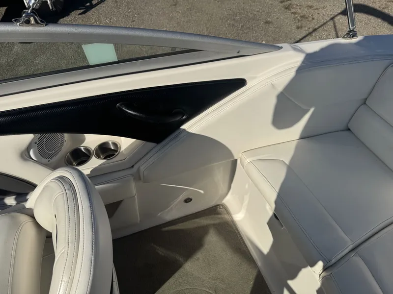 Slide: The Image of Interior of a 2009 Monterey 194FS boat with white seating and cup holders. - 16