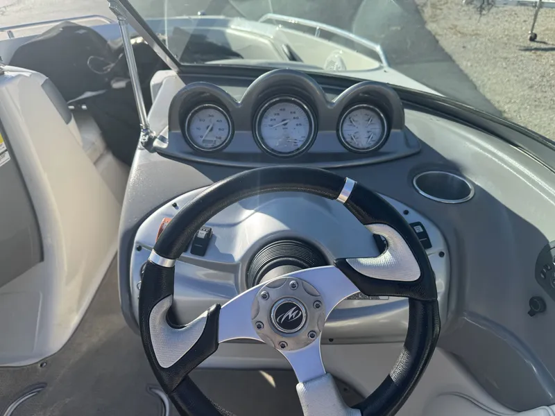 Slide: The Image of Steering wheel and dashboard of a 2009 Monterey 194FS boat, featuring gauges and controls. - 21
