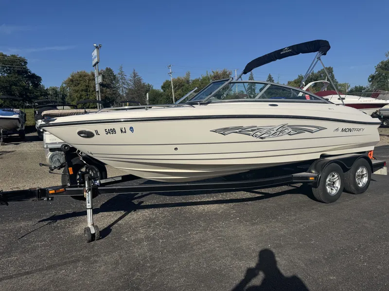 Slide: The Image of 2009 Monterey 194FS boat on trailer, parked outdoors under clear blue sky. - 3