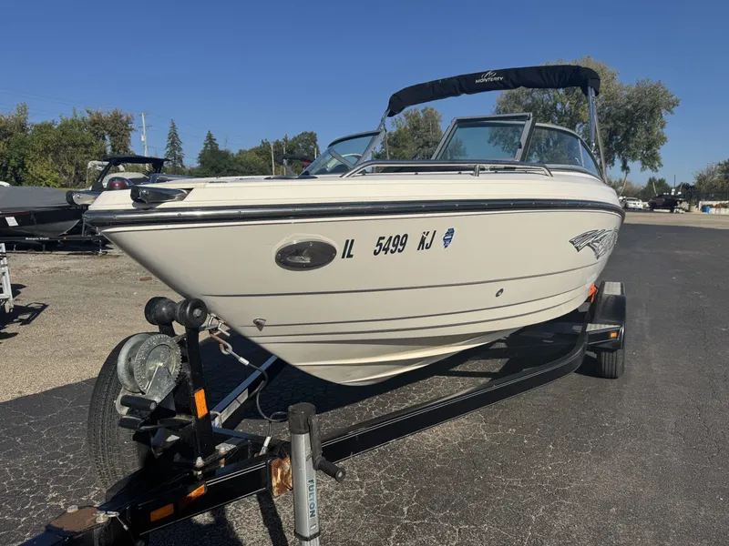 Slide: The Image of 2009 Monterey 194FS boat on trailer, parked outdoors under clear blue sky. - 4
