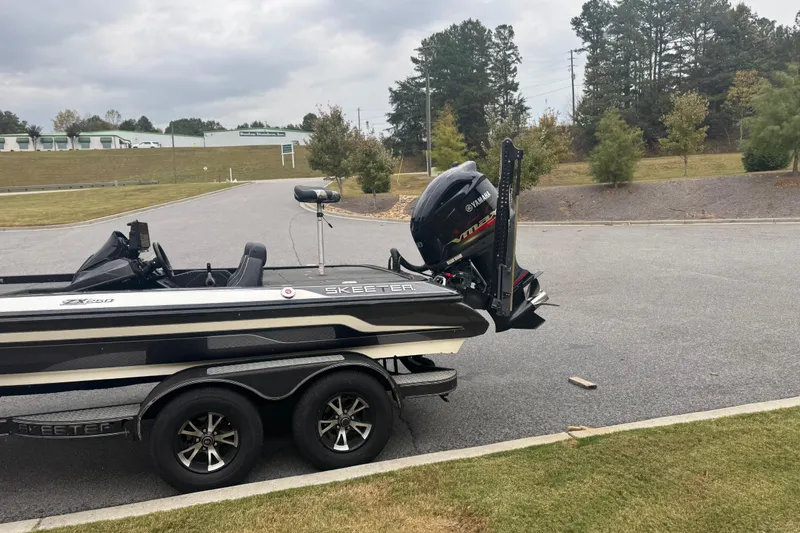 Slide: The Image of 2019 Skeeter ZX250 boat on trailer with Yamaha engine, parked outdoors. - 11