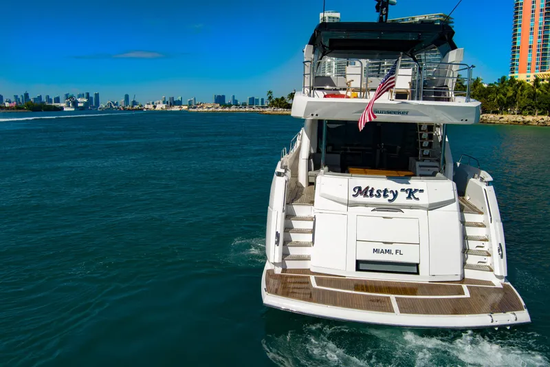 Slide: The Image of 2024 Sunseeker 76 Yacht cruising in Miami waters, rear view with city skyline. - 10