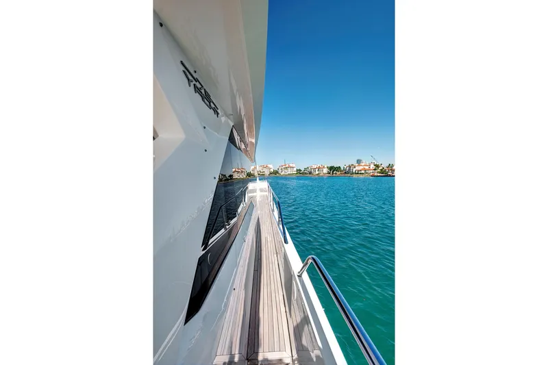 Slide: The Image of Side view of 2024 Sunseeker 76 Yacht cruising on clear blue waters. - 12