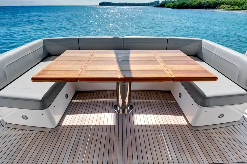 Slide: The Image of Luxurious Sunseeker 76 Yacht 2024 deck with elegant seating and wooden table, overlooking serene waters. - 14