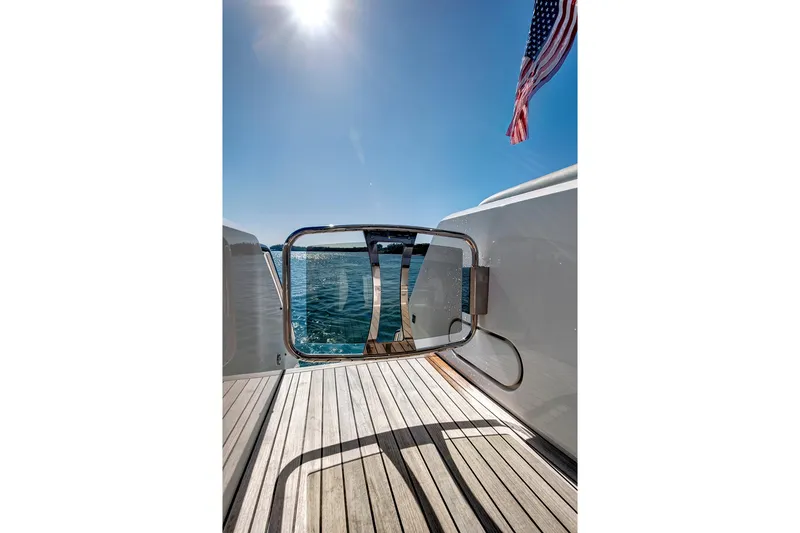 Slide: The Image of 2024 Sunseeker 76 Yacht deck with ocean view and American flag. - 18