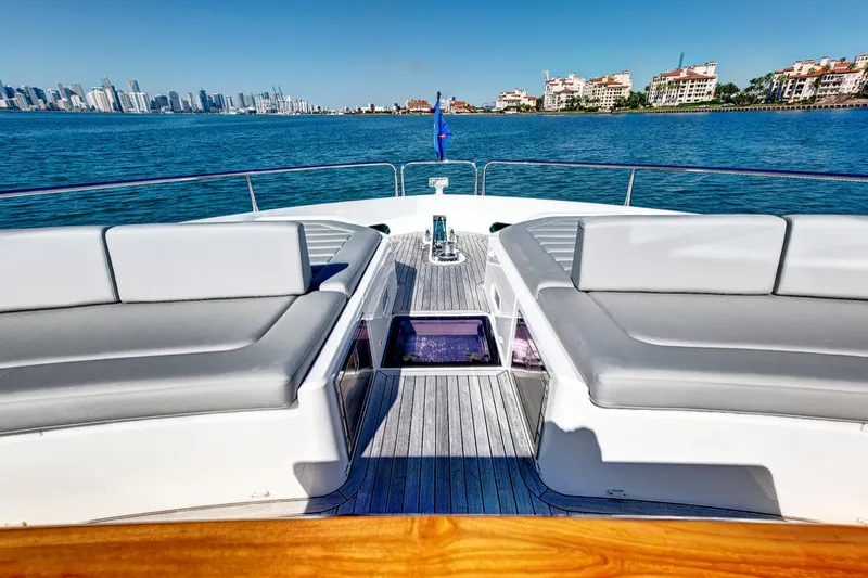 Slide: The Image of 2024 Sunseeker 76 Yacht deck with luxurious seating, overlooking a vibrant city skyline. - 22