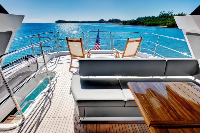 Slide: The Image of Luxurious 2024 Sunseeker 76 Yacht deck with seating, ocean view, and American flag. - 28