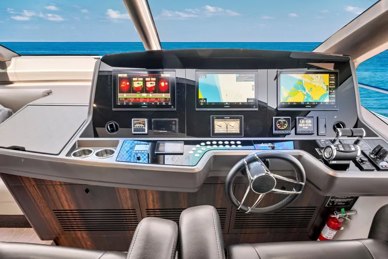 Slide: The Image of 2024 Sunseeker 76 Yacht helm with advanced navigation displays and controls, overlooking the ocean. - 46