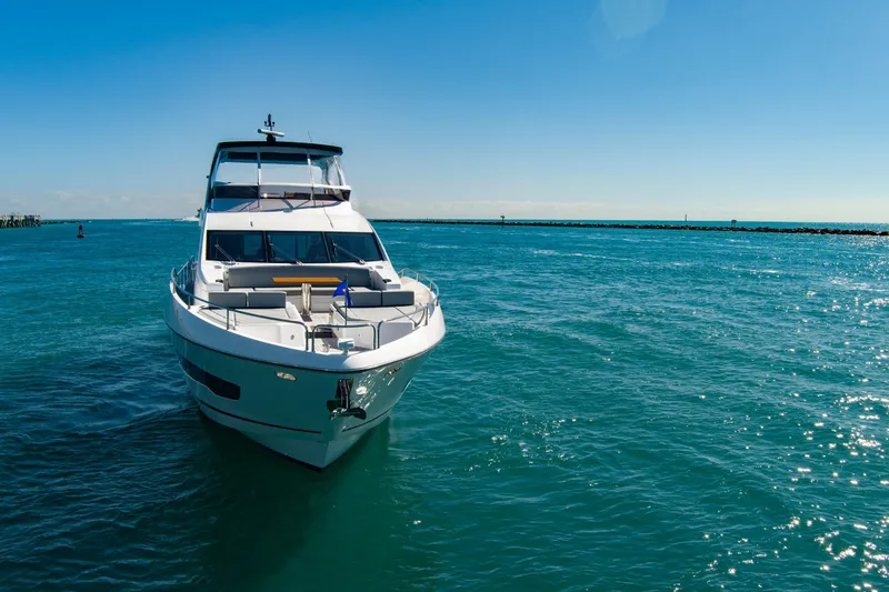 Slide: The Image of 2024 Sunseeker 76 Yacht cruising on clear blue ocean under sunny sky. - 5